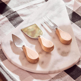 Set of cheese tools on a marble board with a checkered tablecloth