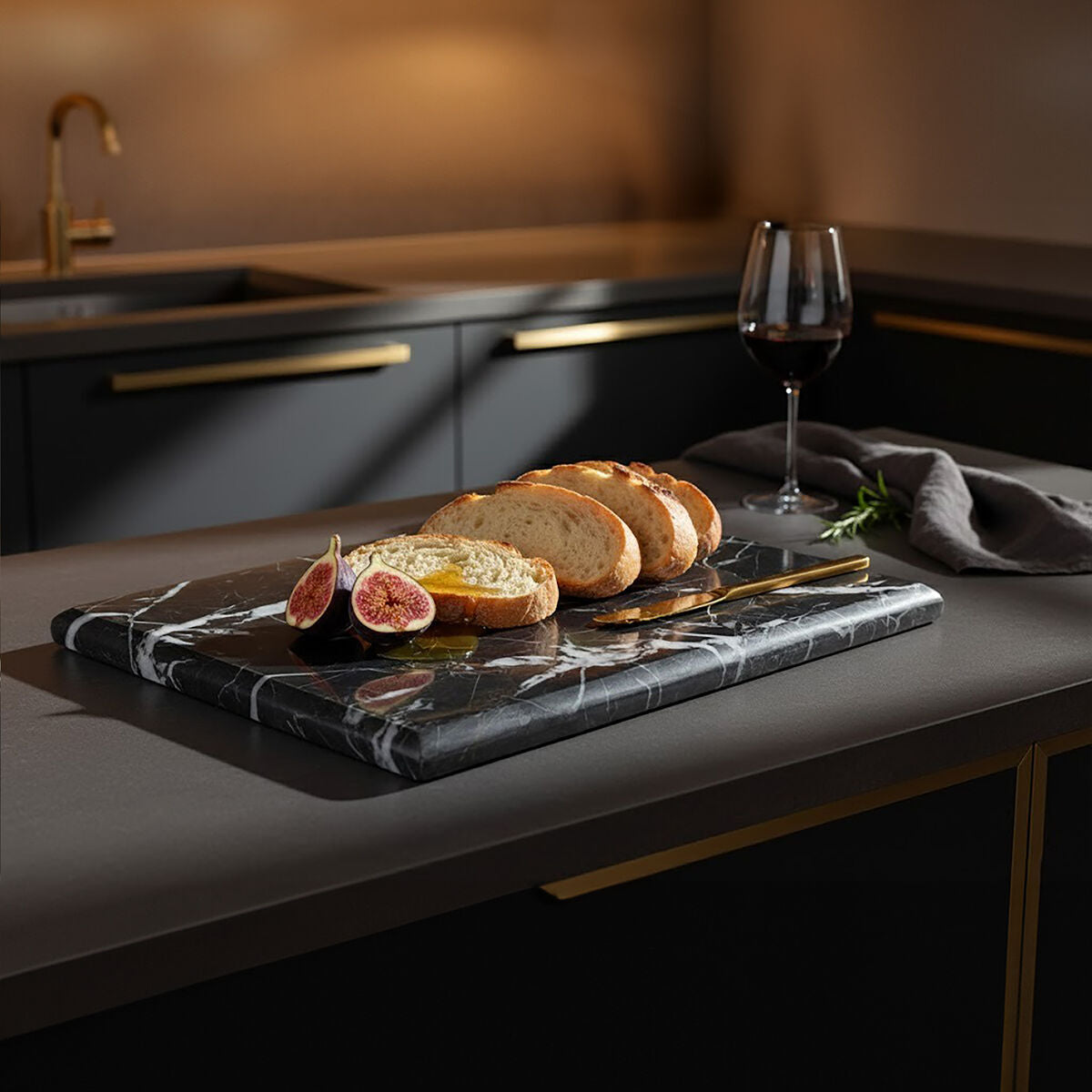 Platter of bread and figs with a glass of red wine on a kitchen counter.