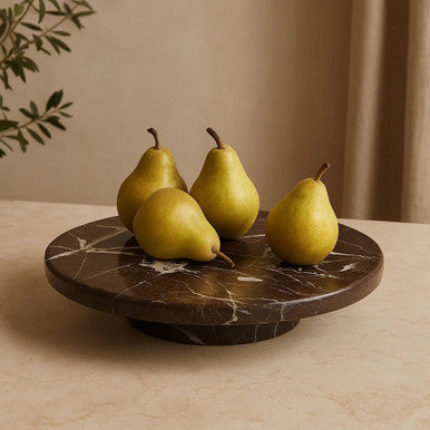 Four green pears on a dark marble tray with a neutral background