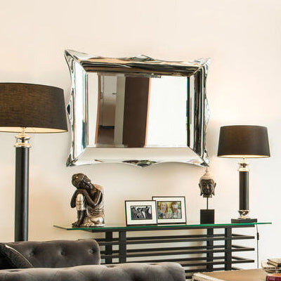 Modern living room with gray tufted sofa, coffee table, and decorative items.