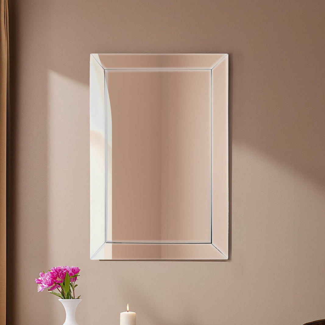 Rectangular mirror on a beige wall with a small table and decorative items below.