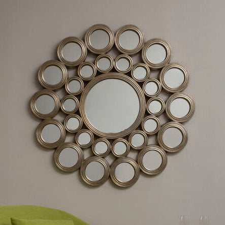 Green sofa in a room with a decorative mirror on the wall.
