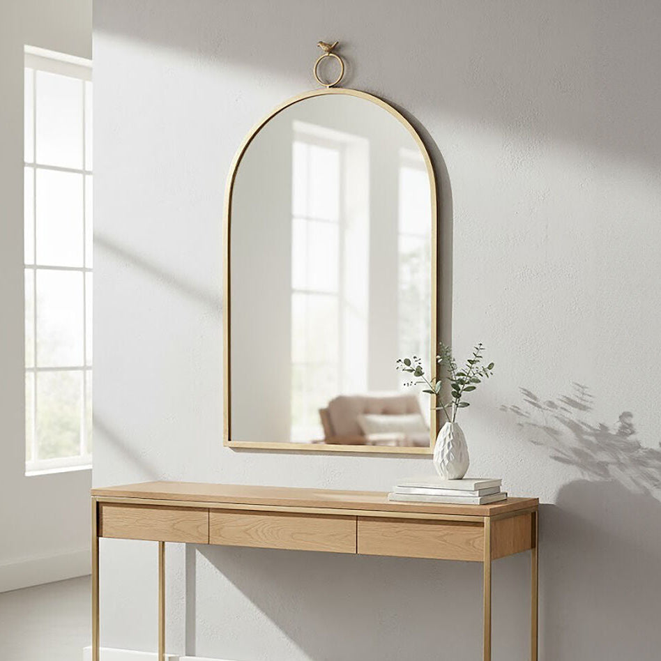 Wooden console table with gold legs against a white wall with a large mirror above it.
