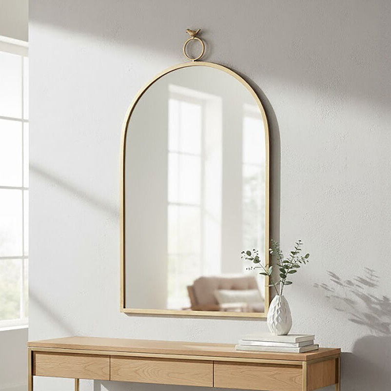 Wooden console table with gold legs against a white wall with a large mirror above it.