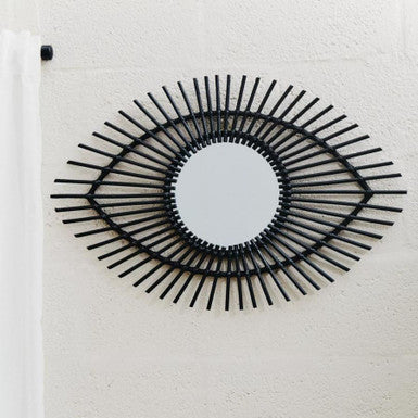 Decorative wall mirror with eye design on a white background
