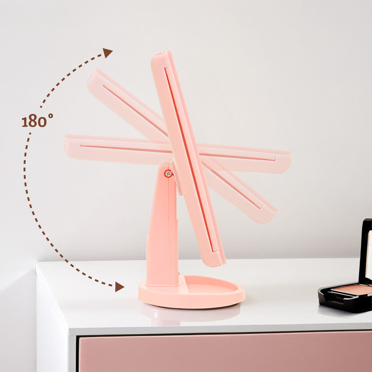 Pink adjustable desk lamp on a white surface with a neutral background
