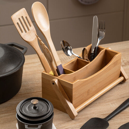 Wooden utensil holder with kitchen tools on a wooden surface