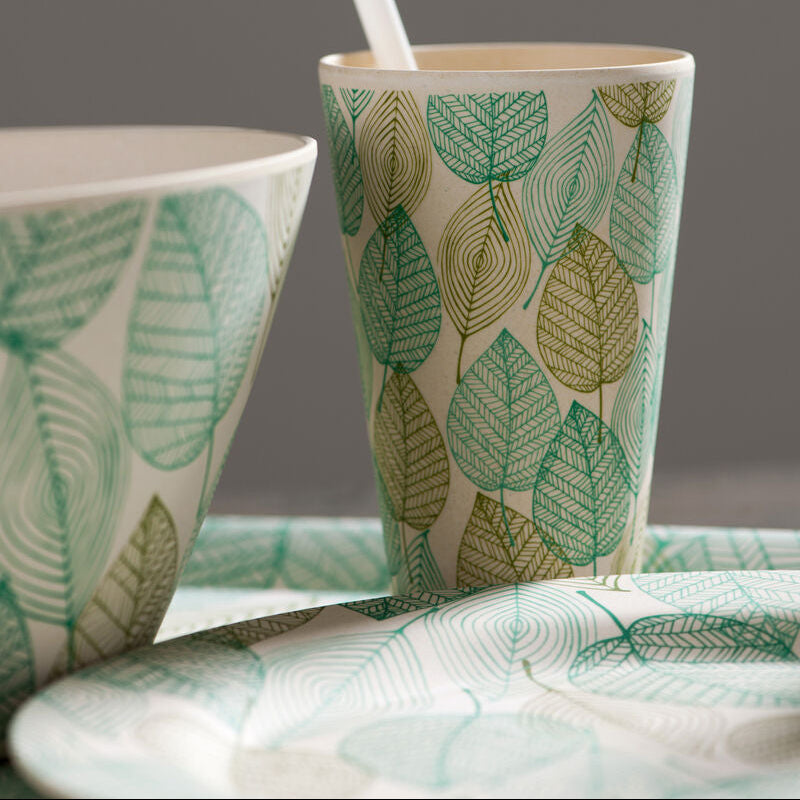 Two ceramic cups with leaf pattern on a gray background