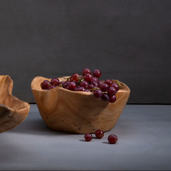 Wooden bowl with grapes on a dark background