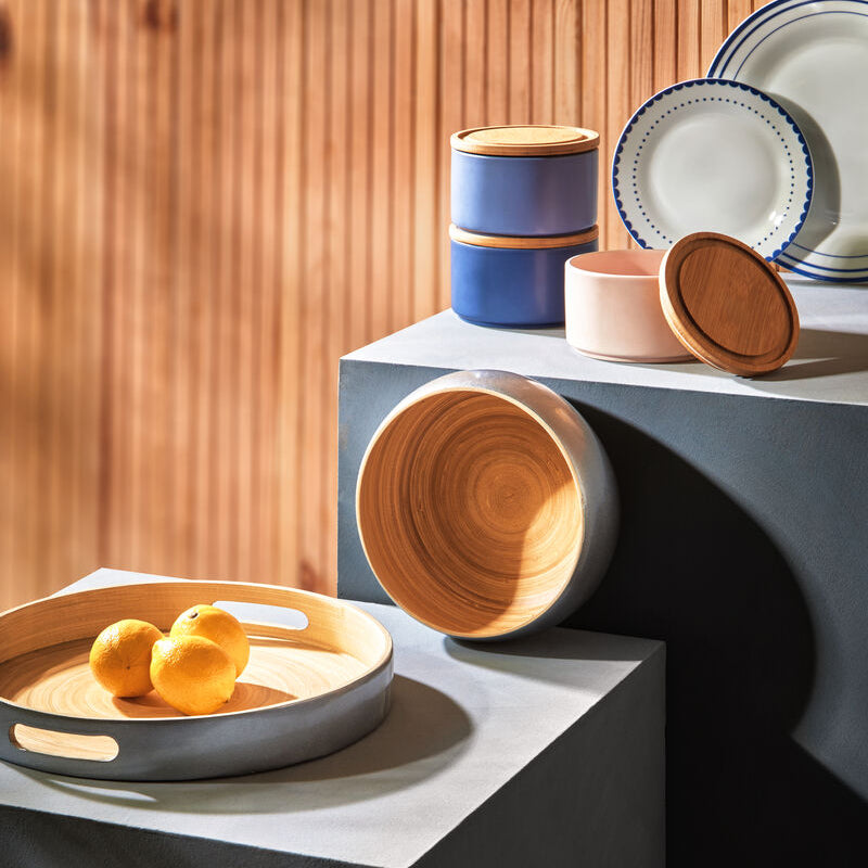 Set of ceramic bowls and plates on a modern surface with a wooden background