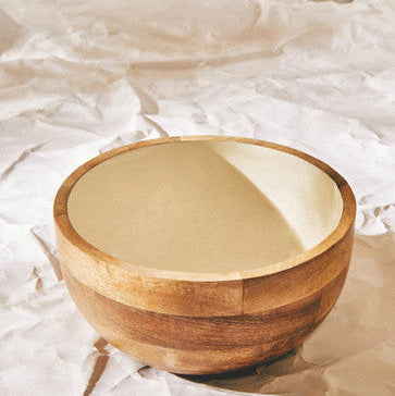 Wooden bowl on crumpled white paper