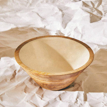 Wooden bowl on crumpled white paper