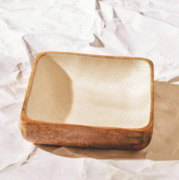 Rectangular wooden box with a beige interior on crumpled white paper