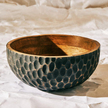 Wooden bowl with textured surface on a white background