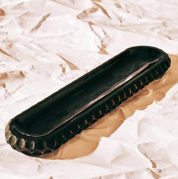 Black and gold shoe shine block on a textured white and brown background