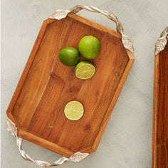 Wooden cutting board with limes on a textured surface