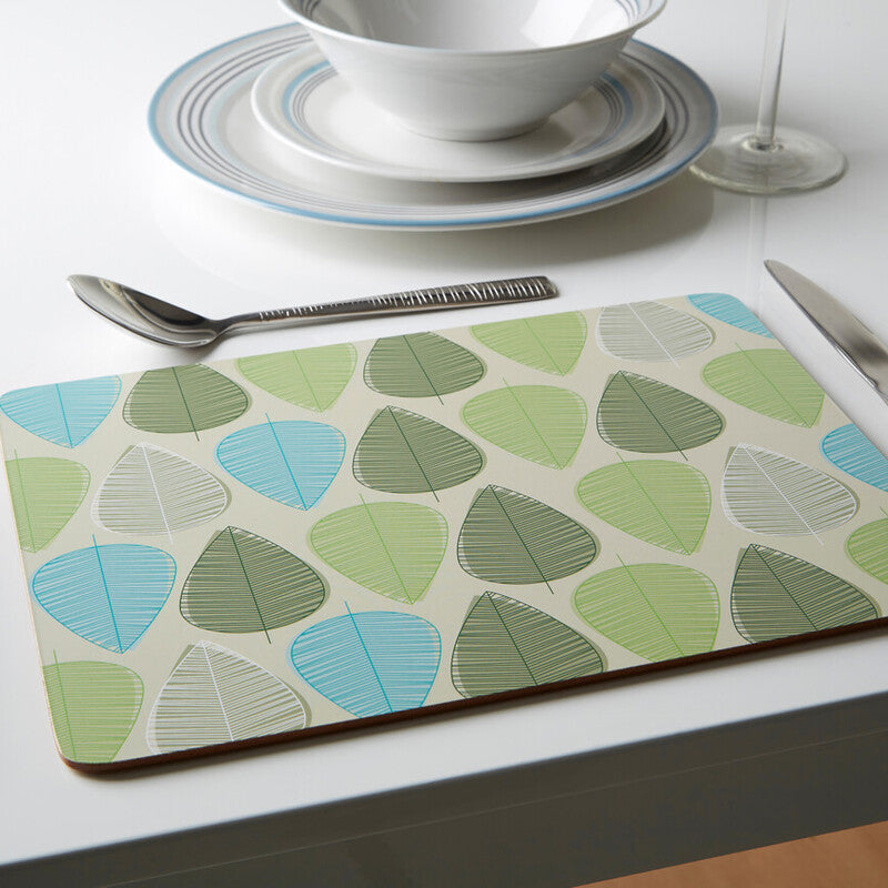 Placemat with leaf pattern on a table setting with cutlery and plates.