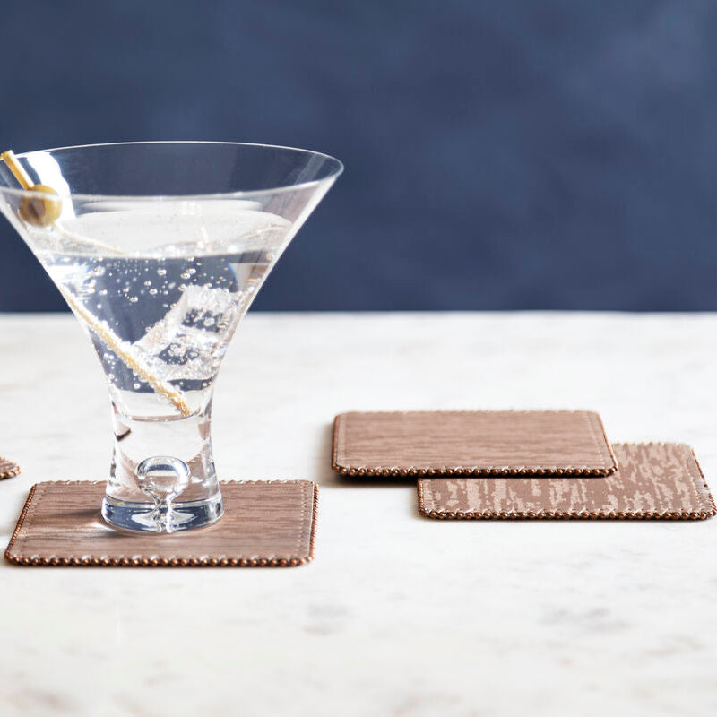 Martini glass with a cocktail on a marble surface with coasters