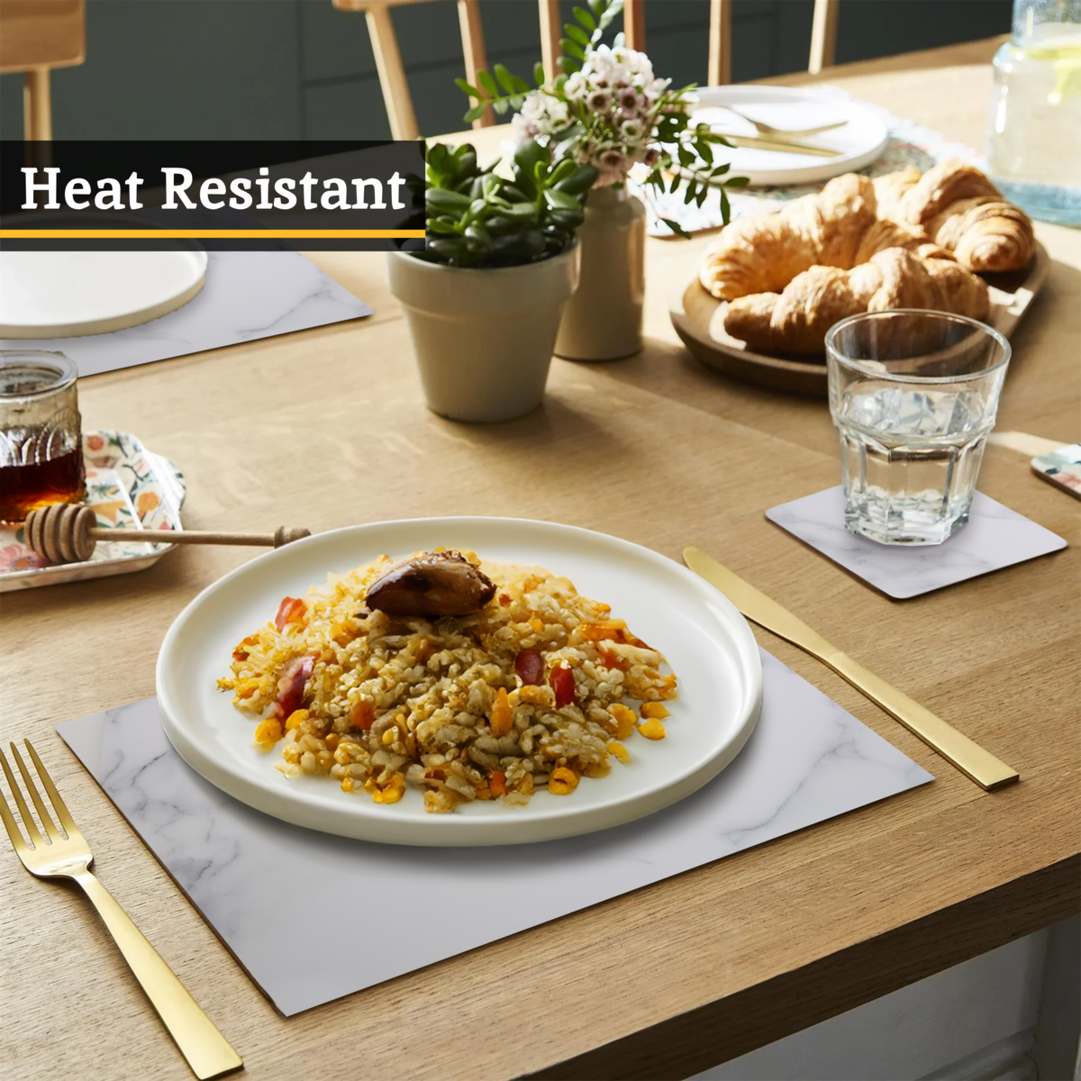 Dining table setting with a plate of food, glasses, and croissants on a wooden table.