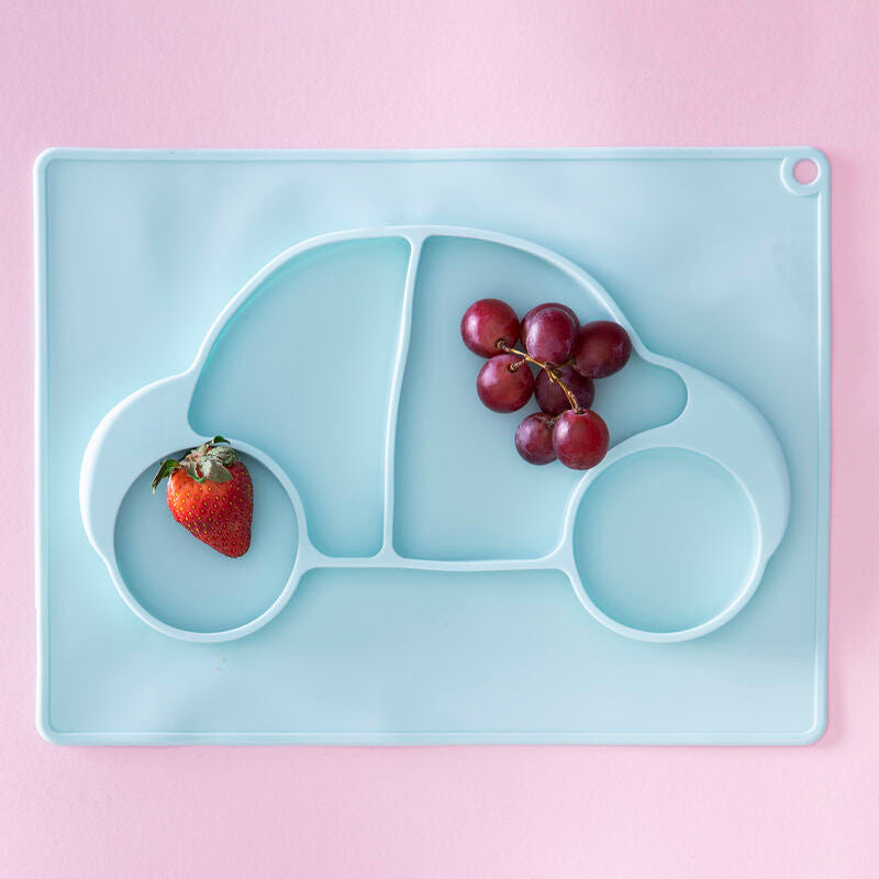 Light blue car-shaped tray with a strawberry and grapes on a pink background