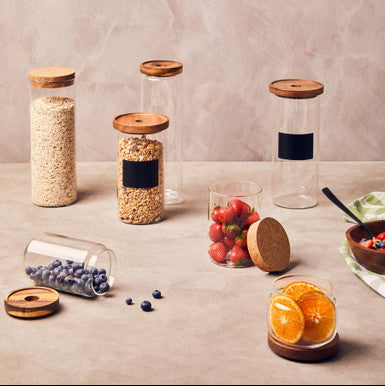Set of glass jars with wooden lids on a neutral background