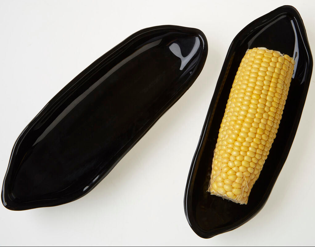 Corn on a black plate on a white background