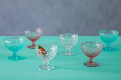 Set of glass dessert bowls with a blue and pink gradient on a teal background