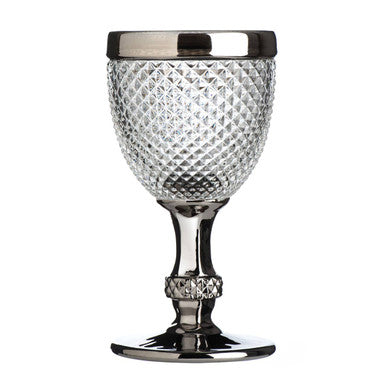 Decorative glass goblet with diamond pattern and metallic rim on a white background