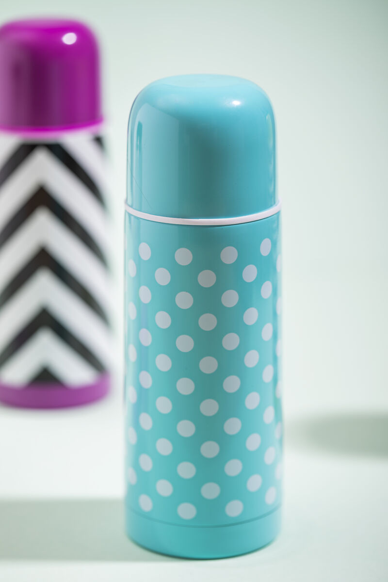 Blue thermos with white polka dots on a light gray background