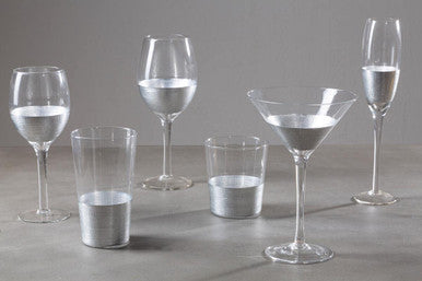 Set of various glassware with water on a gray surface