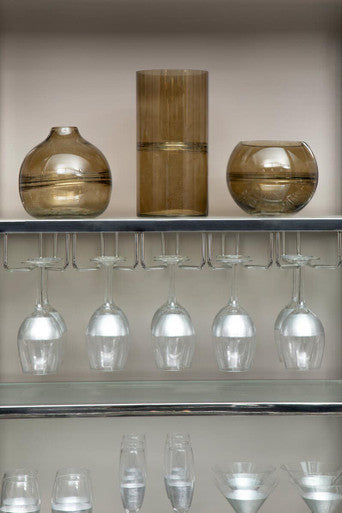 Shelves with decorative glass items and wine glasses in a kitchen setting