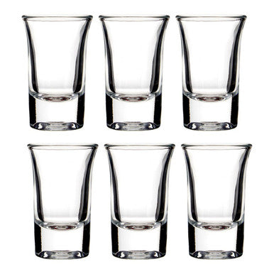 Set of six clear shot glasses on a white background