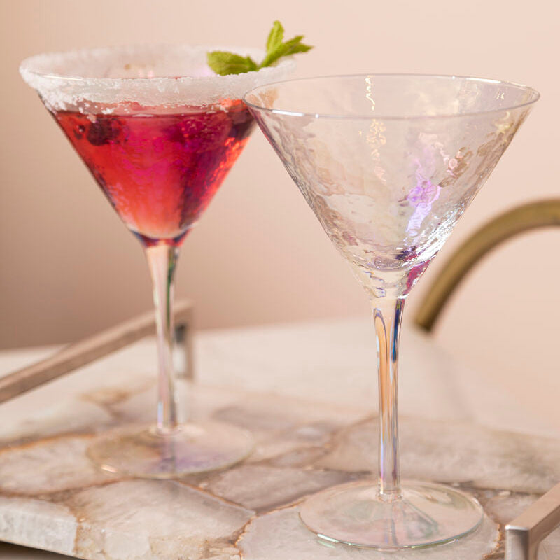 Two cocktail glasses on a marble surface with a neutral background