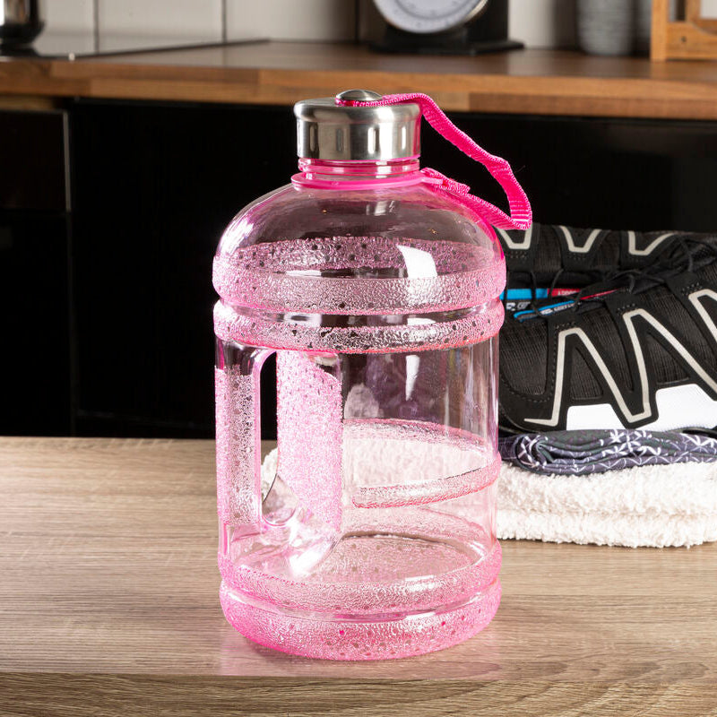 Pink water bottle with a black and white sneaker on a wooden surface