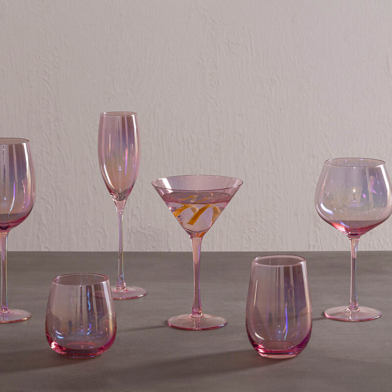 Set of iridescent glassware on a gray surface with a neutral background