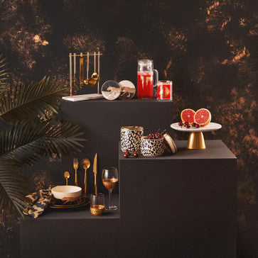 Decorative setup with candles, glasses, and decorative items on a dark background