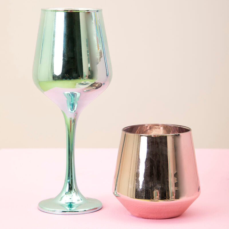 Two metallic wine glasses on a pink surface with a light beige background