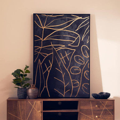 Wooden TV stand with decorative plant and abstract wall art in a room.
