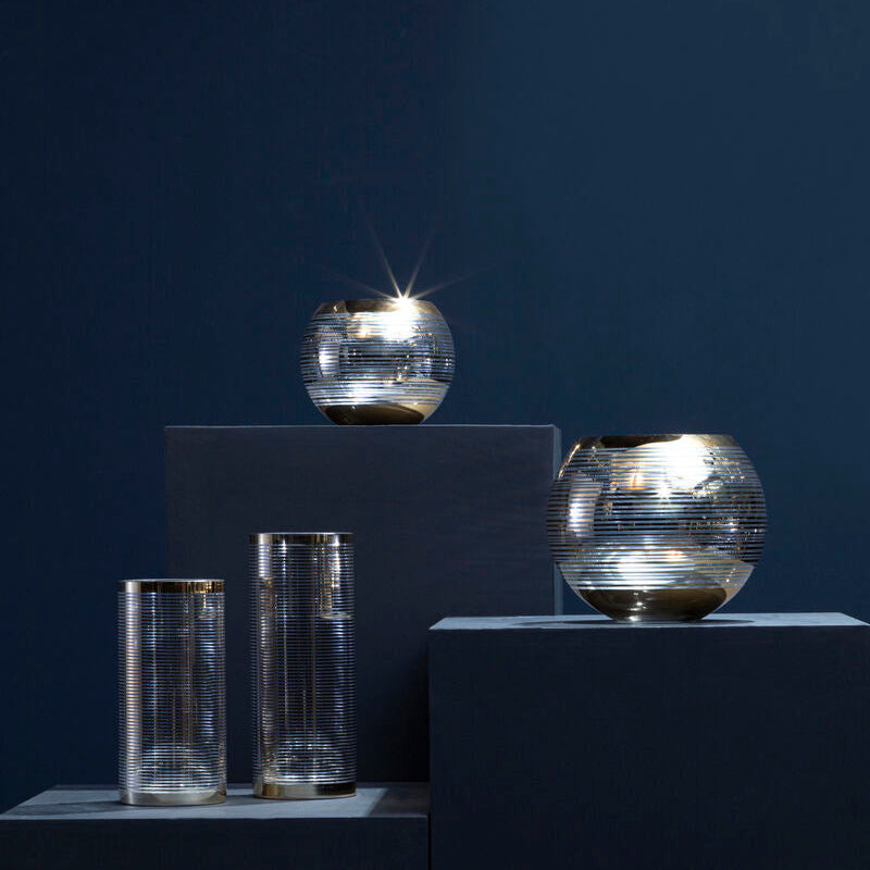 Set of glass containers on dark gray cubes against a dark blue background
