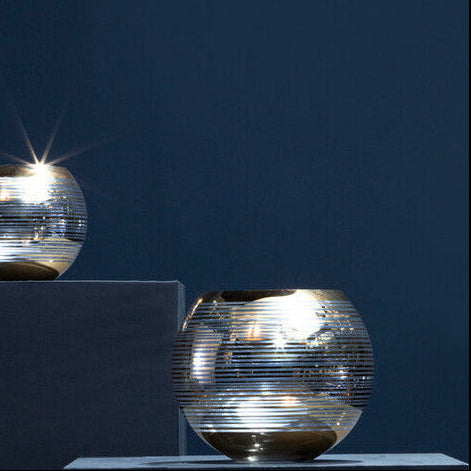 Set of metallic glass containers on a dark blue background