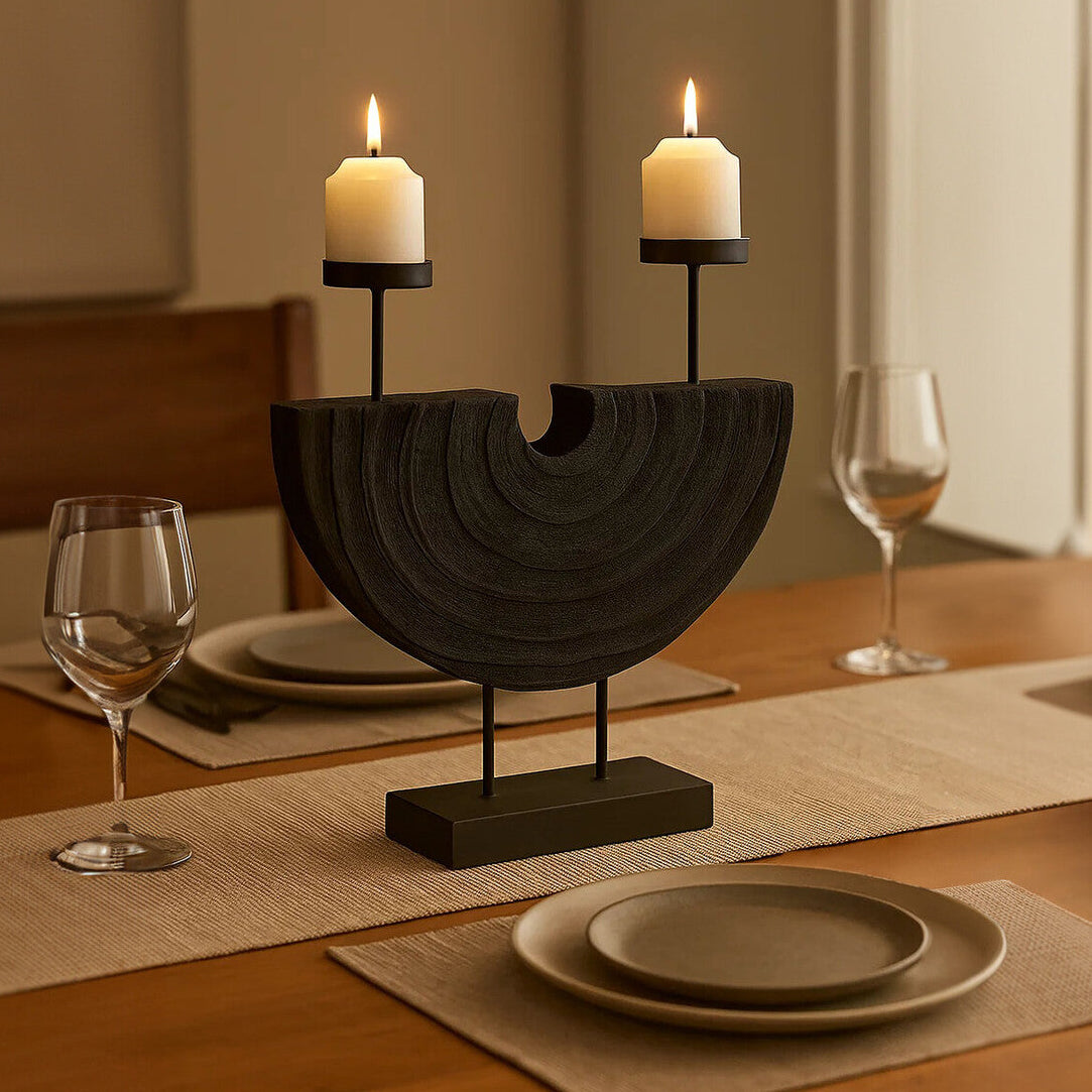 Decorative candle holder with two lit candles on a table setting.