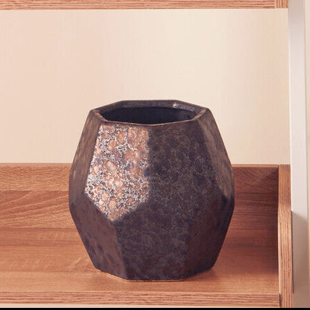 Set of dark ceramic vases on wooden shelves with a neutral background