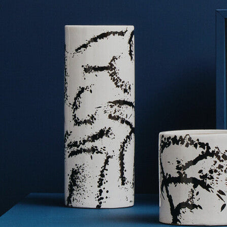 Ceramic vases with black abstract patterns on a blue and beige background