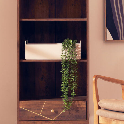 Modern interior with a wooden bookshelf, beige armchair, and abstract art on the wall.