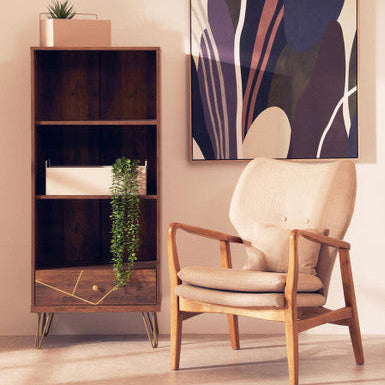 Wooden armchair and bookshelf in a room with abstract art on the wall.