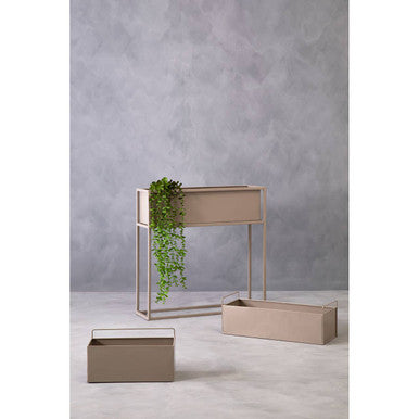 Set of beige planters with a glass container on a gray background