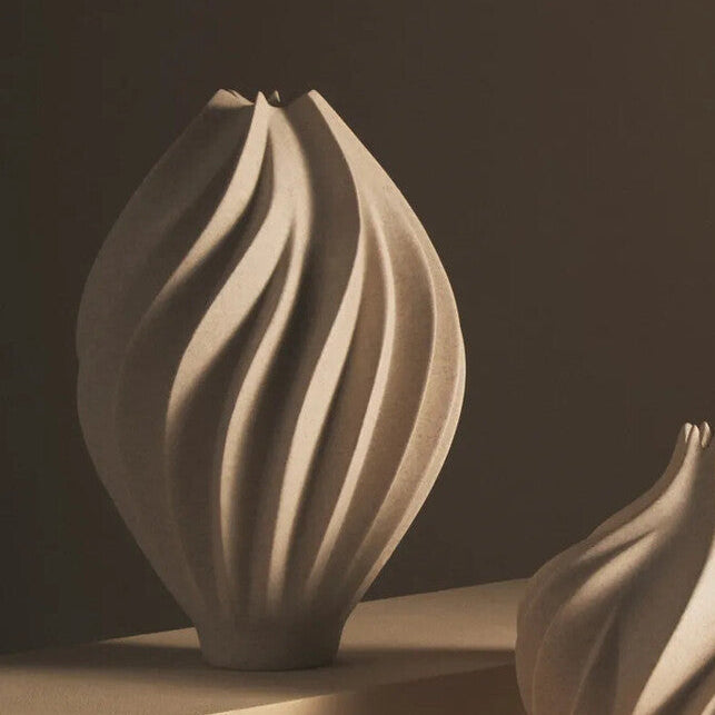 Two ceramic vases with textured surfaces on a neutral background