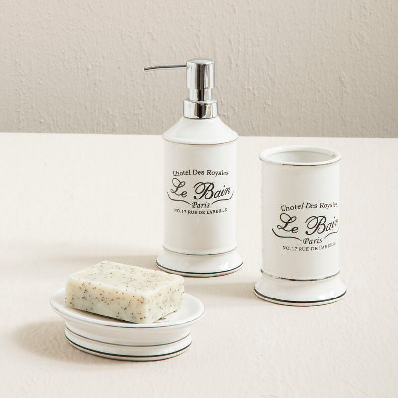 Bathroom set with white dispenser, soap dish, and small container labeled &
