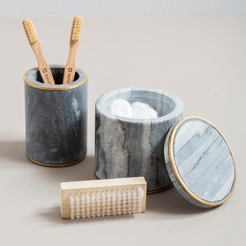 Marble-textured bathroom set with containers and bamboo toothbrushes on a light gray background