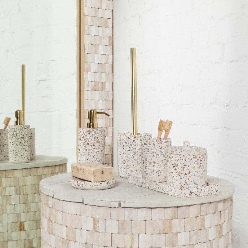 Bathroom setting with mosaic-tiled walls and a round vanity table with decorative items.